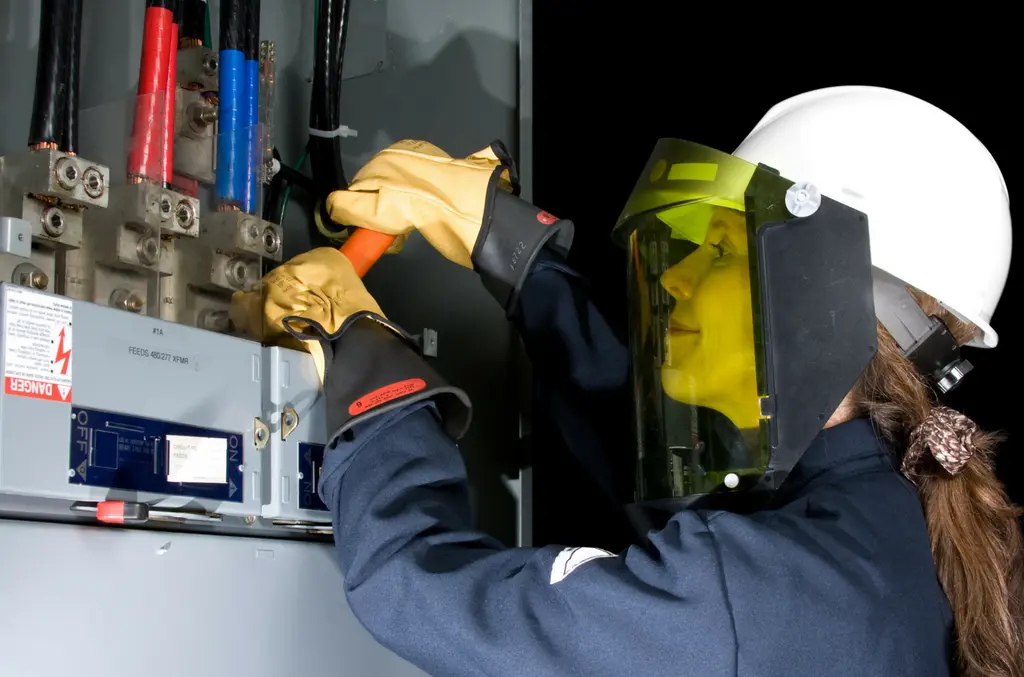 Female electrical worker wearing arc flash PPE using insulated tools on energized panel