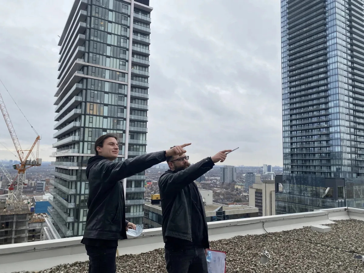 Electrical engineers conducting a rooftop site assessment for arc flash safety and compliance in Toronto